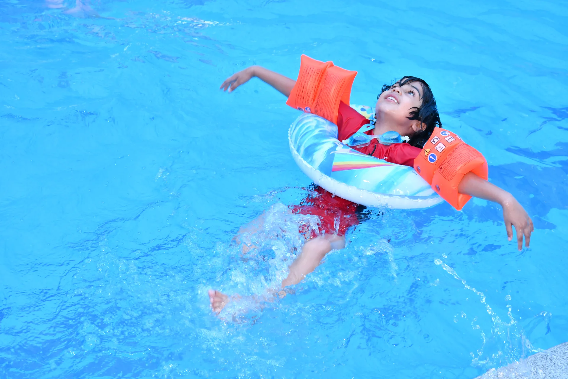 Students practicing swimming strokes under coach guidance